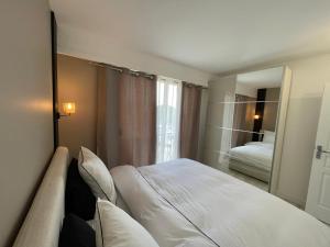 圣罗兰度瓦Appartement bord de mer avec piscine的酒店客房,配有床和镜子