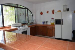 库奥特拉莫雷洛斯Tequesquitengo, Morada del sol的厨房配有炉灶和白色冰箱。