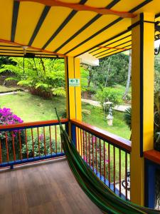 Belén de UmbríaHotel Hacienda San Isidro的门廊上的吊床,享有花园景色
