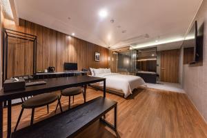 SeosanBrown Dot Hotel Seosan的酒店客房 - 带一张床和一张带椅子的桌子