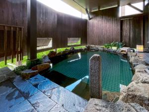 高山飞騨高山旅程酒店的一座石墙房子内的游泳池