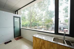 邦美蜀Thanh Ngọc Motel的一个带水槽和大窗户的厨房