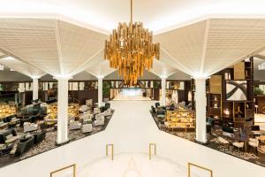 迪拜Le Méridien Dubai Hotel & Conference Centre的装饰着吊灯的酒店大厅的 ⁇ 染