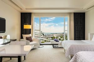 迪拜Le Méridien Dubai Hotel & Conference Centre的酒店客房设有一张床和一个大窗户