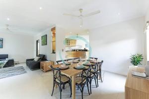 Stuart ParkZenhouse (Bayview) 4BR Luxury Family Home Pool/BBQ的用餐室以及带桌椅的起居室。