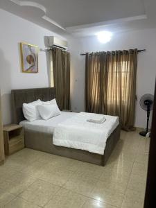 拉各斯Beautiful 2Br Apt in Ogba, Ikeja, Lagos的一间卧室配有一张带白色床单的大床