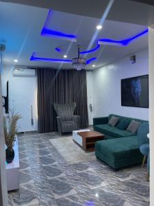 拉各斯Beautiful 2Br Apt in Ogba, Ikeja, Lagos的客厅配有绿色沙发和桌子