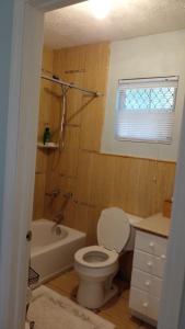 拿骚Lynn's Cozy Cottage的浴室配有卫生间、浴缸和水槽。