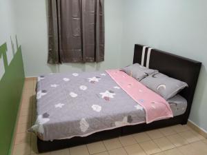 怡保QQ Homestay的卧室配有带灰色棉被的床