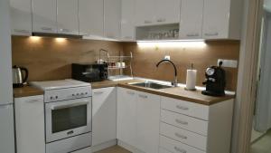 桑丹斯基Парк Апартаменти Юлия的厨房配有白色橱柜和水槽