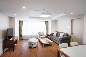 釜山釜山皇冠海港酒店的客厅配有沙发和桌子