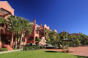 马贝拉瓦萨里度假酒店的一座棕榈树建筑,前面有一个草坪