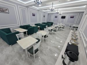 撒马尔罕OLD STATION HOTEL的餐厅设有绿色的椅子、桌子和椅子