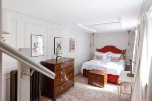 布莱顿霍夫Brighton Brunswick Apartments的一间卧室配有一张床和一个木制梳妆台