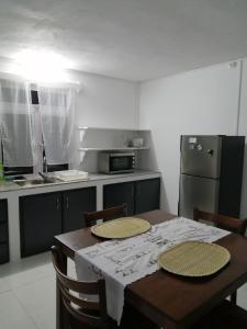 Rodrigues IslandÔ Bercail du Sud chez Jeannette的厨房配有桌椅和冰箱。