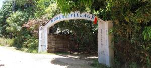 圣玛丽Boraha Village Ecolodge的拱门,上面标有院子村的标志