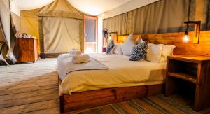 奥马鲁鲁Ondudu Safari Lodge的帐篷内一间卧室,配有一张大床