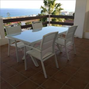 马尼尔瓦2056 - Apt with terrace sea view的阳台上配有白色的桌椅,享有海景