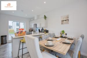 海尔St Ives Bay - Immaculate Brand New 3Bed - Free Parking - Beach - WiFi的厨房以及带木桌和椅子的用餐室。