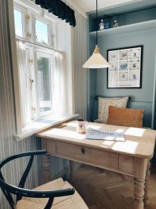 凡岛Fanø Krogaard的配有2扇窗户的客房内的一张木桌
