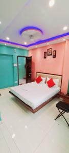 瓦拉纳西Hotel Ananya Inn的卧室配有带红色枕头的大型白色床