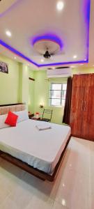 瓦拉纳西Hotel Ananya Inn的一间卧室设有一张大床,拥有紫色的天花板