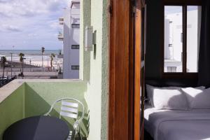 特拉维夫Residence Suites BY RAPHAEL HOTELS的客房设有一张床和一张桌子,享有海滩美景。