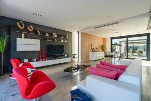 柳维M4R Architect House Llubi的客厅配有白色沙发和红色椅子