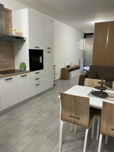 科洛尼奥蒙泽塞Einaudi Apartment的厨房配有白色橱柜和桌椅