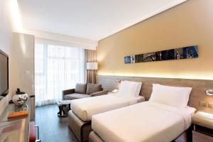 香港Lodgewood by Nina Hospitality Mong Kok的酒店客房,设有两张床和一张沙发