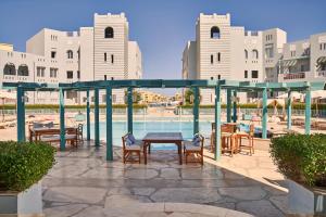 赫尔格达Fanadir Hotel El Gouna的池畔露台配有桌椅