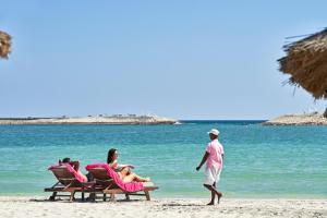 塞拉莱Juweira Boutique Hotel Adult only的一群人坐在沙滩上的椅子上