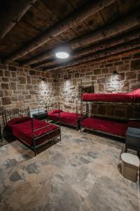 拜特龙Cedar Scent Guesthouse的砖墙内带三张双层床的房间