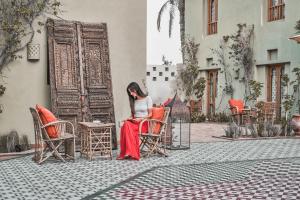 赫尔格达阿里帕夏酒店的坐在建筑物前椅子上的女人