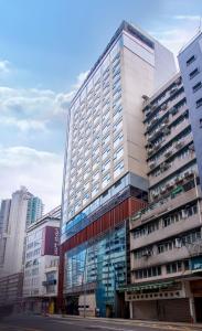 香港Lodgewood by Nina Hospitality Mong Kok的一座高大的建筑,在城市里装有玻璃窗