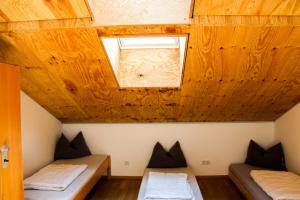 施利尔塞Jugendherberge Schliersee的配有木天花板的客房内的两张床