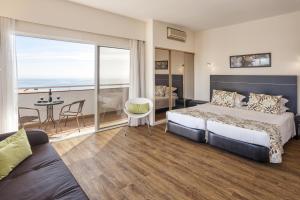 阿尔沃尔佩斯塔纳艾尔瓦艾特拉提克住宅海滩套房酒店的酒店客房设有一张床和一个阳台。