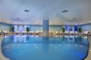 埃尔祖鲁姆帕兰滑雪及会议度假酒店的酒店的大型游泳池配有桌椅