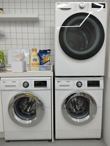 光州Athene Motel的厨房配有两台洗衣机以及洗衣机和烘干机。