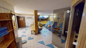 Jenig披若斯劳尔山酒店的一间设有蓝色椅子的房间和一间带桌子的房间