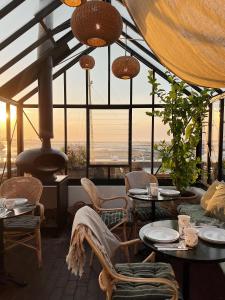 凡岛Fanø Krogaard的一间设有桌椅的海景餐厅