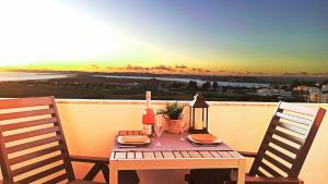 阿尔沃尔Torralta Alvor Beach 601的一张木桌,上面放着一瓶葡萄酒和一杯