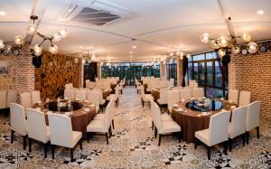 下龙湾Haradise Suite Villa & Homestay Ha Long的宴会厅配有桌子和白色椅子