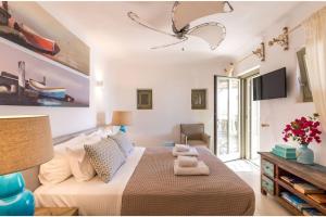 DexamenesElite Mykonos Villa - Villa Roxane - Private Pool - 6 Bedrooms - Beachfront - Ftelia的一间带大床和电视的卧室