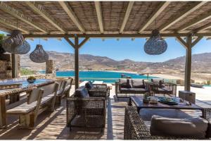 DexamenesElite Mykonos Villa - Villa Roxane - Private Pool - 6 Bedrooms - Beachfront - Ftelia的一个带桌椅的海景庭院