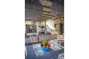 DexamenesElite Mykonos Villa - Villa Roxane - Private Pool - 6 Bedrooms - Beachfront - Ftelia的用餐室配有带一碗水果的桌子