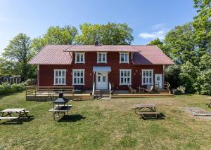 勒托普Villa Högby的一间红色的大房子,前面设有野餐桌
