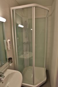 易拉斯加威Ylläs Lake Hotel的一个带水槽的玻璃淋浴间