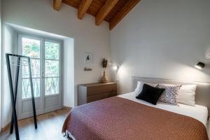 梅纳焦Il Castello - by MyHomeInComo的一间卧室设有一张床和一个大窗户