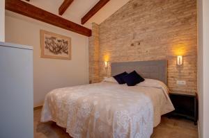 瓦伦西亚Beds & Breaks Verdi 2的一间卧室设有一张床和砖墙